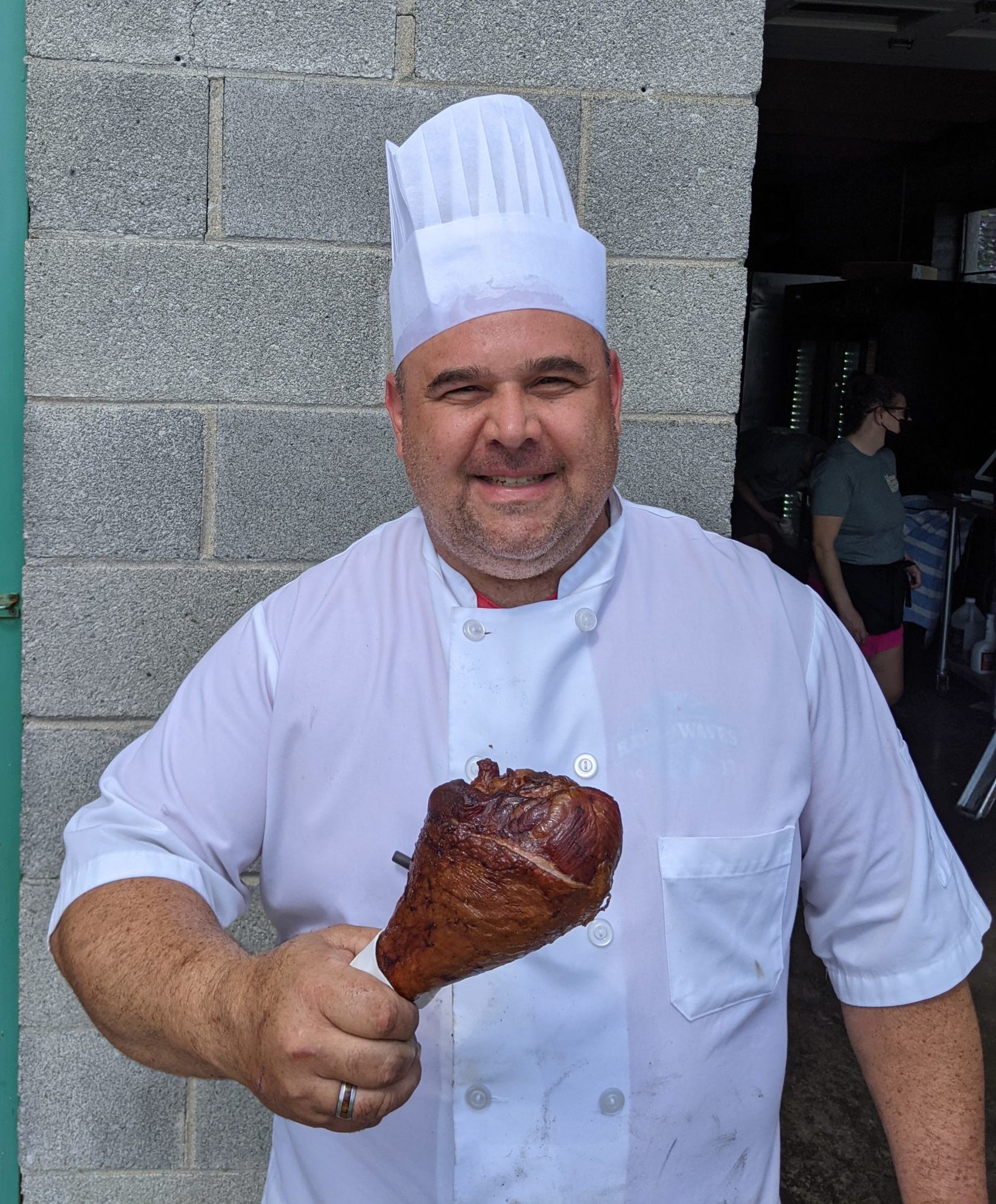 Chef Luca holding a Turkey Leg outside of the Farm Building.